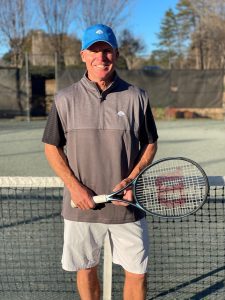 Mac Kantor Standing in front of a Tennis Net at Raintree Country Club