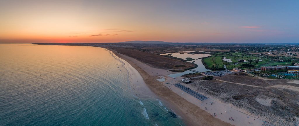 A aerial view of the golf course and beach at salgados golf club at sunset 